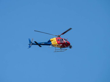 Villafranca del Bierzo, İspanya; 08-31-2024: RTVE (İspanyol radyo ve televizyon) helikopteri (CS-HEE) 2024 Vuelta a Espaa bisiklet yarışını mavi gökyüzü üzerinde tamamen uçarak yayınlamaktan sorumlu