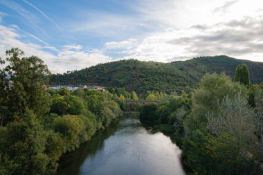 Sil Nehri, Ponferrada şehrinden geçerken, yaya köprüsü ve tren istasyonuna ve arka plandaki Pajariel dağına erişim sağlayan bir demiryolu köprüsünün altında.