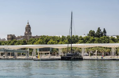 Malaga, İspanya; 07 / 09 / 2024: Malaga Katedrali 'nin manzarası ve kentin liman bölgesinin ticari ve gezinti alanı olan Pier One' dan gelen yatlar ve özel tekneler için mevcut liman alanı