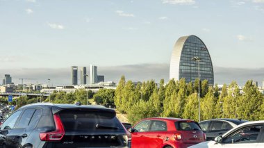 Madrid, Spain; 09-18-2024: Traffic jam on the road entering Madrid, Spain, with a view of the iconic 5 office towers on Castellana Avenue and the BBVA headquarters building in the background clipart