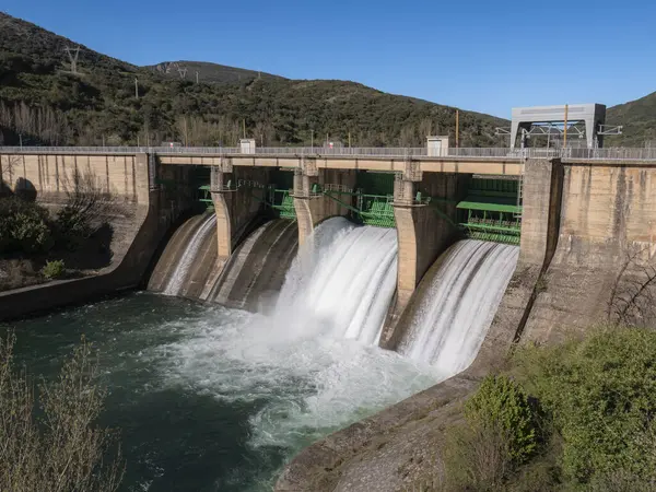 İki baraj kapağının açık olduğu Sil Nehri 'ndeki Pearrubia rezervuar barajının genel manzarası büyük bir su akışını serbest bırakarak aşağı doğru beyaz bir dere oluşturuyor.