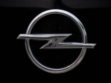 Madrid, İspanya; 08-21-2025: Otomobil üreticisinin enerji ve hızını sembolize eden metalik siyah bir arabaya yerleştirilmiş gümüş bir dairenin içinde yıldırım şeklinde Opel marka logo (Blitz)