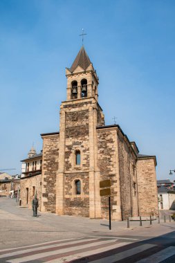 Ponferrada, Leon, İspanya; 09-11-2024; Ponferrada 'daki San Andrs Kilisesi' nin ana cephesi, tepesindeki kulesinin ve çanlarının altını çiziyor ve Lamb Chupacandiles heykelinin koruması altında.