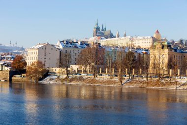 Çek Cumhuriyeti 'nin güneşli bir günde Vltava Nehri üzerindeki Prag Kalesi ile Karlı Prag Küçük Kasabası