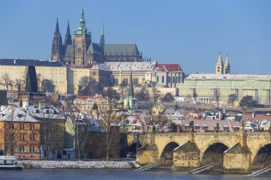 Çek Cumhuriyeti 'nin güneşli bir günde Vltava Nehri üzerindeki Prag Kalesi ile Karlı Prag Küçük Kasabası