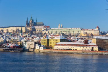 Çek Cumhuriyeti 'nin güneşli bir günde Vltava Nehri üzerindeki Prag Kalesi ile Karlı Prag Küçük Kasabası