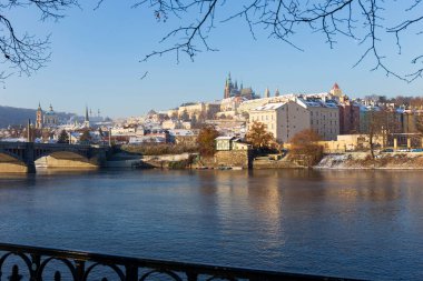 Çek Cumhuriyeti 'nin güneşli bir günde Vltava Nehri üzerindeki Prag Kalesi ile Karlı Prag Küçük Kasabası