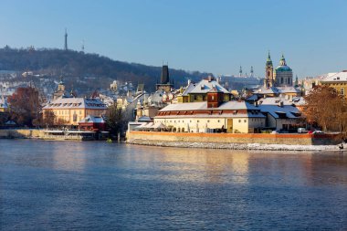 Çek Cumhuriyeti 'nin güneşli bir günde Vltava Nehri üzerindeki Prag Kalesi ile Karlı Prag Küçük Kasabası