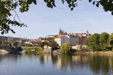 Çek Cumhuriyeti 'nin güneşli bir gününde Vltava Nehri üzerindeki Gotik Şatosu ile Sonbahar Renkli Prag Küçük Kasabası