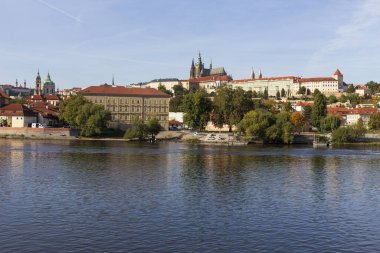 Çek Cumhuriyeti 'nin güneşli bir gününde Vltava Nehri üzerindeki Gotik Şatosu ile Sonbahar Renkli Prag Küçük Kasabası