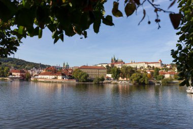 Çek Cumhuriyeti 'nin güneşli bir gününde Vltava Nehri üzerindeki Gotik Şatosu ile Sonbahar Renkli Prag Küçük Kasabası