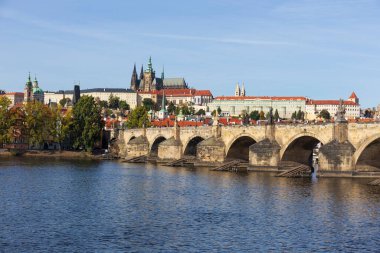 Çek Cumhuriyeti 'nin güneşli bir gününde Vltava Nehri üzerindeki Gotik Kalesi ve Charles Köprüsü ile Sonbahar Renkli Prag Küçük Kasabası