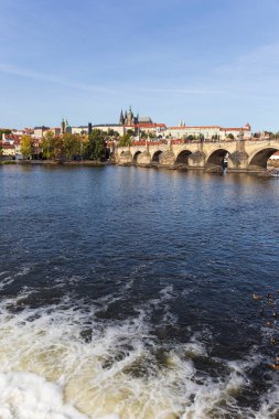 Çek Cumhuriyeti 'nin güneşli bir gününde Vltava Nehri üzerindeki Gotik Kalesi ve Charles Köprüsü ile Sonbahar Renkli Prag Küçük Kasabası