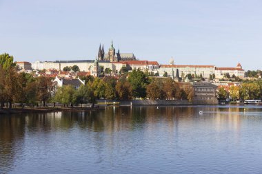 Çek Cumhuriyeti 'nin güneşli bir gününde Vltava Nehri üzerindeki Gotik Kalesi ve Charles Köprüsü ile Sonbahar Renkli Prag Küçük Kasabası