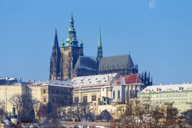 Çek Cumhuriyeti 'nin güneşli bir günde Vltava Nehri üzerindeki Prag Kalesi ile Karlı Prag Küçük Kasabası