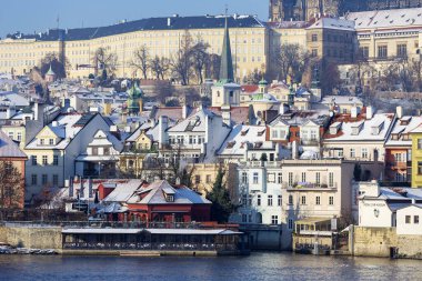 Çek Cumhuriyeti 'nin güneşli bir günde Vltava Nehri üzerindeki Prag Kalesi ile Karlı Prag Küçük Kasabası