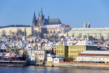 Çek Cumhuriyeti 'nin güneşli bir günde Vltava Nehri üzerindeki Prag Kalesi ile Karlı Prag Küçük Kasabası