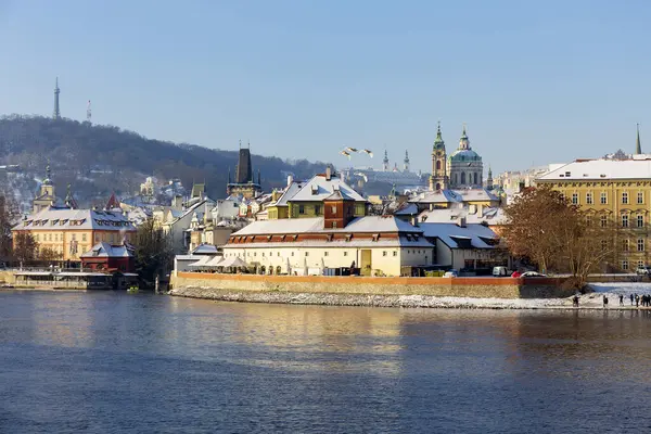 Çek Cumhuriyeti 'nin güneşli bir günde Vltava Nehri üzerindeki Prag Kalesi ile Karlı Prag Küçük Kasabası