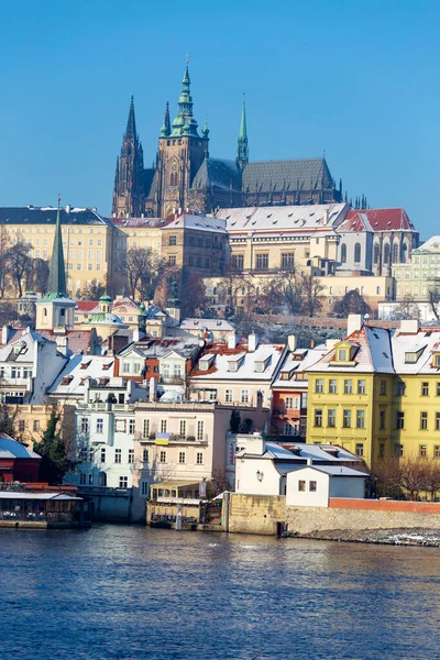 Çek Cumhuriyeti 'nin güneşli bir günde Vltava Nehri üzerindeki Prag Kalesi ile Karlı Prag Küçük Kasabası