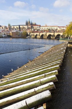 Çek Cumhuriyeti 'nin güneşli bir günde Vltava Nehri üzerindeki Prag Kalesi ile Karlı Prag Küçük Kasabası
