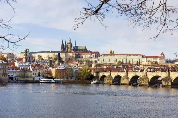 Çek Cumhuriyeti 'nin güneşli bir günde Vltava Nehri üzerindeki Prag Kalesi ile Karlı Prag Küçük Kasabası