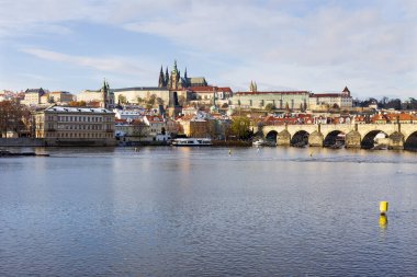 Çek Cumhuriyeti 'nin güneşli bir günde Vltava Nehri üzerindeki Prag Kalesi ile Karlı Prag Küçük Kasabası