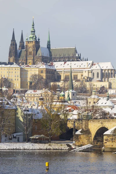 チェコ共和国晴れた日にプラハ城とヴルタヴァ川の上のカレル橋と雪のプラハ小町 ストック写真
