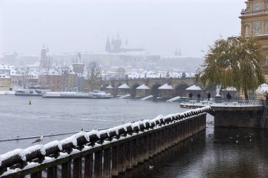 Kar gibi sisli Prag Küçük Kasabası Vltava Nehri üzerindeki gotik kalesiyle, kar yağıyor, Çek Cumhuriyeti