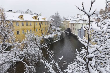 Certovka nehrinin yukarısında romantik sisli Prag Değirmeni kar yağıyor, Çek Cumhuriyeti