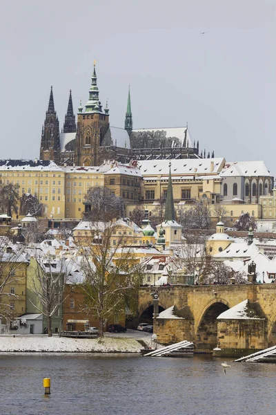 チェコ共和国晴れた日にプラハ城とヴルタヴァ川の上のカレル橋と雪のプラハ小町 ストックフォト
