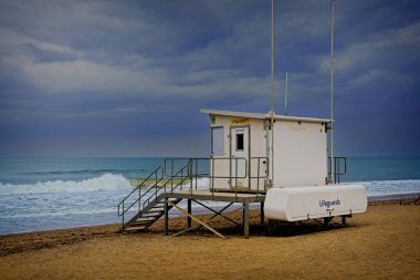 Kasvetli, dramatik bir sahne beyaz bir cankurtaran istasyonunu, yaklaşan fırtına ve dalgaların ortasında Sandsend sahilinde, Kuzey Yorkshire, İngiltere, İngiltere 'de kırılışını gösteriyor..