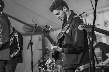 Bir erkek gitarist, New York, Yorkshire, İngiltere 'de canlı bir sahnede gitar solo performansına tamamen dalmış gibi görünüyor..