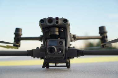 Dji matrisi 30T İHA, sensörleri ve yüksek seviye kamera görüşüyle profesyonel bir Uav 'ın detaylı ön görüntüsü. pistte..