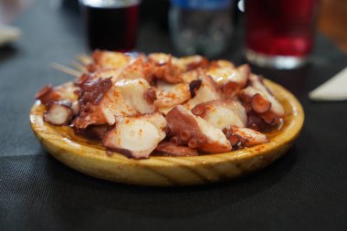 Tipik feira ahtapotu ahşap bir tabakta ve yanında şarap ve ekmekle servis edilir. yatay