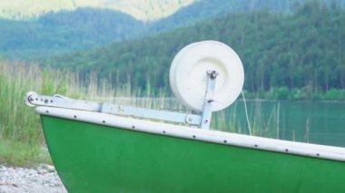 Dağ gölünün kıyısında yeşil bir tekne