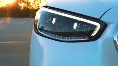 Beyaz Mercedes Maybach gün batımında otoparkın çatısında..