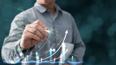 İş adamları büyüme grafikleri ve iş dünyasının ilerlemesini çiziyor ve finans ve yatırımı analiz ediyor. Teknolojiyi başarı hedefleri ve büyümeye yönelik planlar yapmak için kullanın. Çevrimiçi ticaret, e-ticaret, çevrimiçi pazarlama.