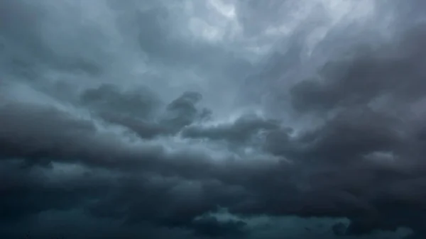 The dark sky with heavy clouds converging and a violent storm before the rain.Bad weather sky.