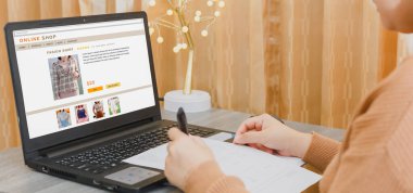 İnternetten alışveriş yapan, internetten ödeme yapan bir kadın, dizüstü bilgisayarla, oturma odasında oturuyor. Dijital para transferi, bankacılık ve ticaret konsepti..