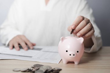 İş adamı kumbaraya madeni para koyuyor, aile finans planı konsepti, bağış toplama, üst yönetim, bağış, hayır kurumu, yatırım, finansal kriz konsepti.