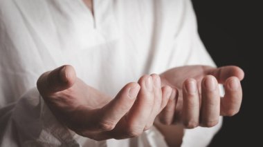 Karanlık arka planda dua edilen bir yetişkin. Dine ve Tanrı 'ya olan inanca saygı. Ön manzara. Barış kavramı.