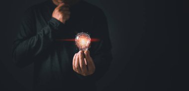 Kişi elinde ampulü tutuyor ve düşünüyormuş gibi yapıyor, ilham, yaratıcılık ve hayal gücü konsepti, yenilik teknolojisi başarı işi.