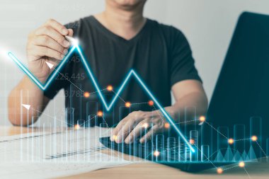 Adam büyüme grafikleri çiziyor ve iş dünyasının ilerlemesini ve finansal ve yatırımları analiz ediyor. Teknolojiyi başarı hedefleri ve büyüyen hisse senetleri için planlamak için kullanın. Çevrimiçi ticaret, e-ticaret, çevrimiçi pazarlama.