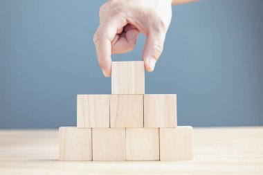 Metin ya da semboller için sekiz blok boş tahta istifleyen bir işadamının eli, büyüme süreci için geliştirme kavramı.