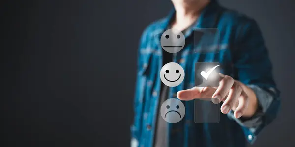 a businessman touching the virtual screen on the happy smile face icon to give satisfaction in service.Customer service and Satisfaction concept.rating very impressed.