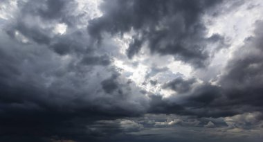 The dark sky with heavy clouds converging and a violent storm before the rain.Bad or night weather sky and environment. carbon dioxide emissions, greenhouse effect, global warming, climate change