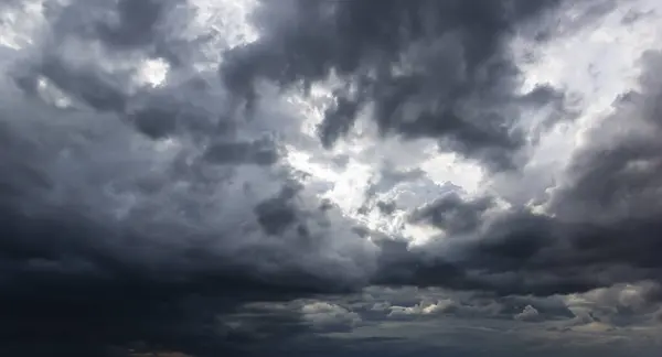 The dark sky with heavy clouds converging and a violent storm before the rain.Bad or night weather sky and environment. carbon dioxide emissions, greenhouse effect, global warming, climate change