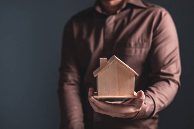 Bir domuz kumbarası, bağış, hayır kurumu, üst yönetim, yatırım, tasarruf, aile finans planı, bir ev satın almak için para biriktirme fikirleri tutan işadamı.