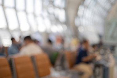 Havaalanındaki yolcu terminalinde bekleyen bir grup yolcunun bulanık görüntüsü.