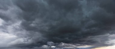 The dark sky with heavy clouds converging and a violent storm before the rain.Bad or night weather sky and environment. carbon dioxide emissions, greenhouse effect, global warming, climate change
